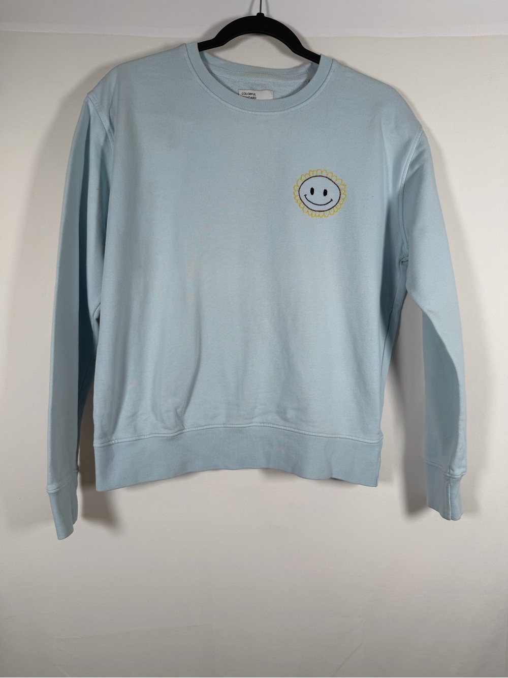Colorful Standard Women’s Light Blue Organic Crewneck Sweatshirt with Smiley Sun